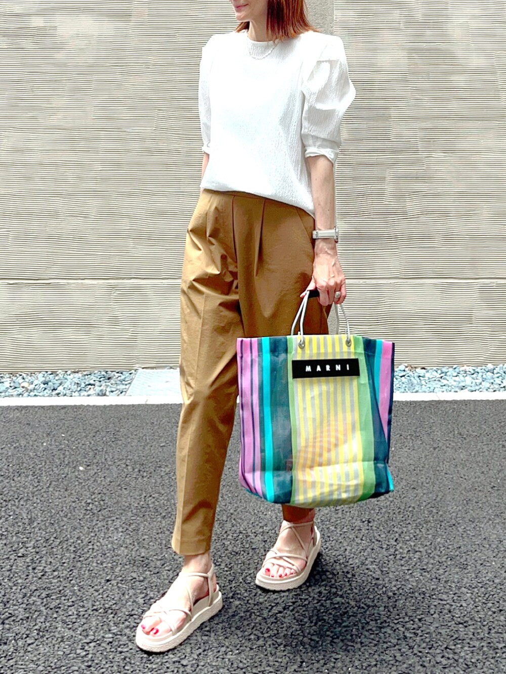 イエロー系のその他パンツ、ホワイト系のサンダル、その他のバッグを着用したレディースの夏コーディネートの2枚目の写真