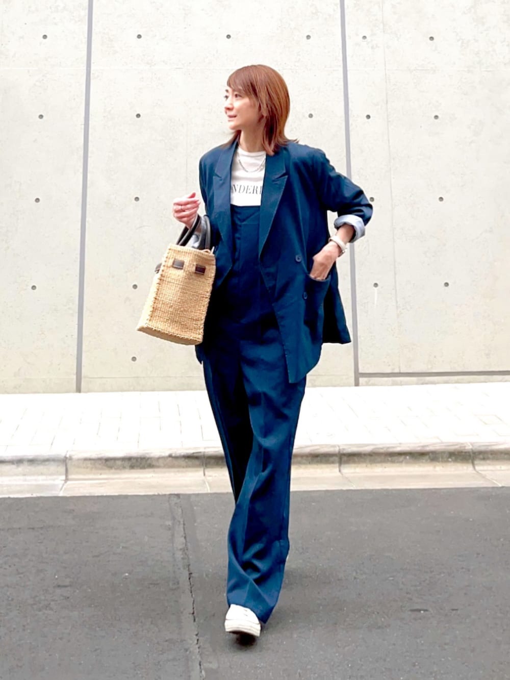 ホワイト系のスニーカー、ブルー系のテーラードジャケット、ブルー系のつなぎ/オールインワンを着用したレディースの春コーディネートの2枚目の写真