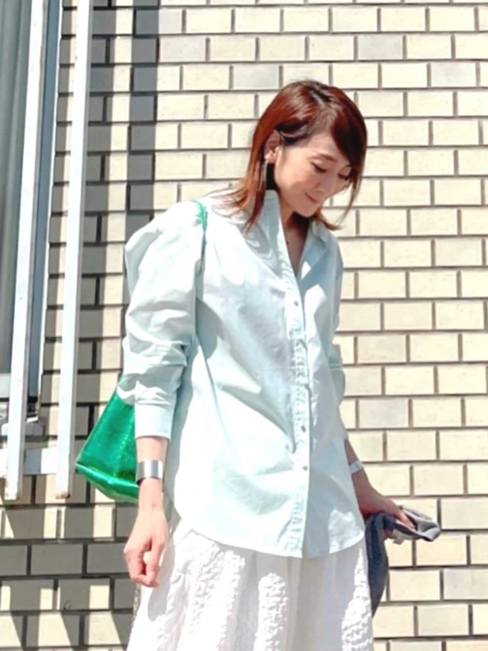 グリーン系のシャツ/ブラウス、ホワイト系のスカート、グリーン系のショルダーバッグを着用したレディースの春コーディネートの2枚目の写真