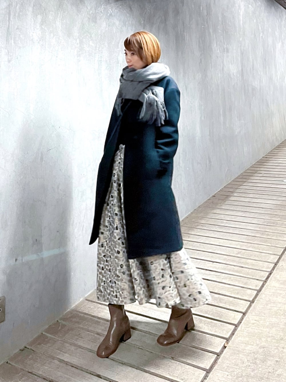 ベージュ系のスカート、ブルー系のニット/セーター、ベージュ系のブーツを着用したレディースの冬コーディネートの4枚目の写真