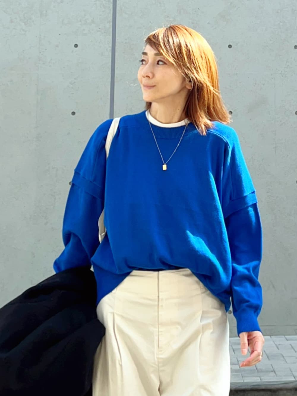 ブルー系のニット/セーター、ホワイト系のその他パンツ、ホワイト系のスニーカーを着用したレディースの春コーディネートの3枚目の写真