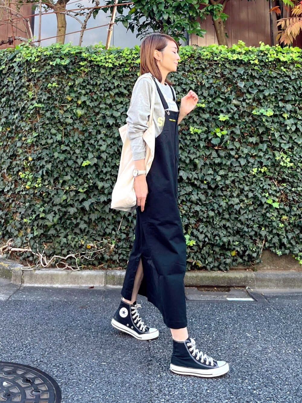 ブラック系のスカート、グレー系のTシャツ/カットソー、ホワイト系のトートバッグを着用したレディースの秋コーディネートの3枚目の写真