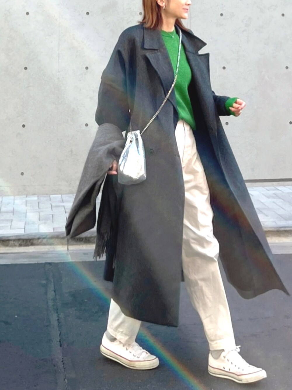 ホワイト系のスニーカー、シルバー系のハンドバッグ、グリーン系のニット/セーターを着用したレディースの冬コーディネートの2枚目の写真