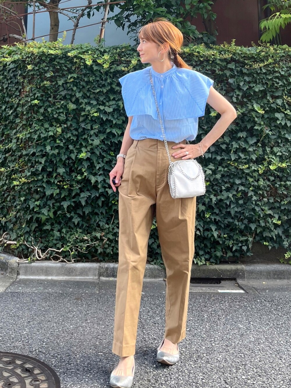 ブルー系のシャツ/ブラウス、ホワイト系のショルダーバッグ、イエロー系のチノパンツを着用したレディースの夏コーディネートの3枚目の写真