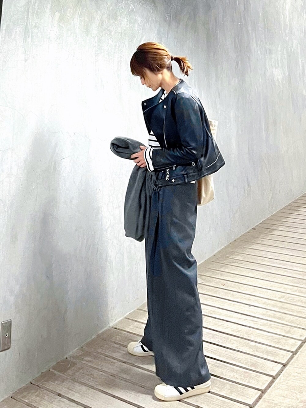 グレー系のスラックス、ホワイト系のTシャツ/カットソー、ホワイト系のスニーカーを着用したレディースの春コーディネートの3枚目の写真