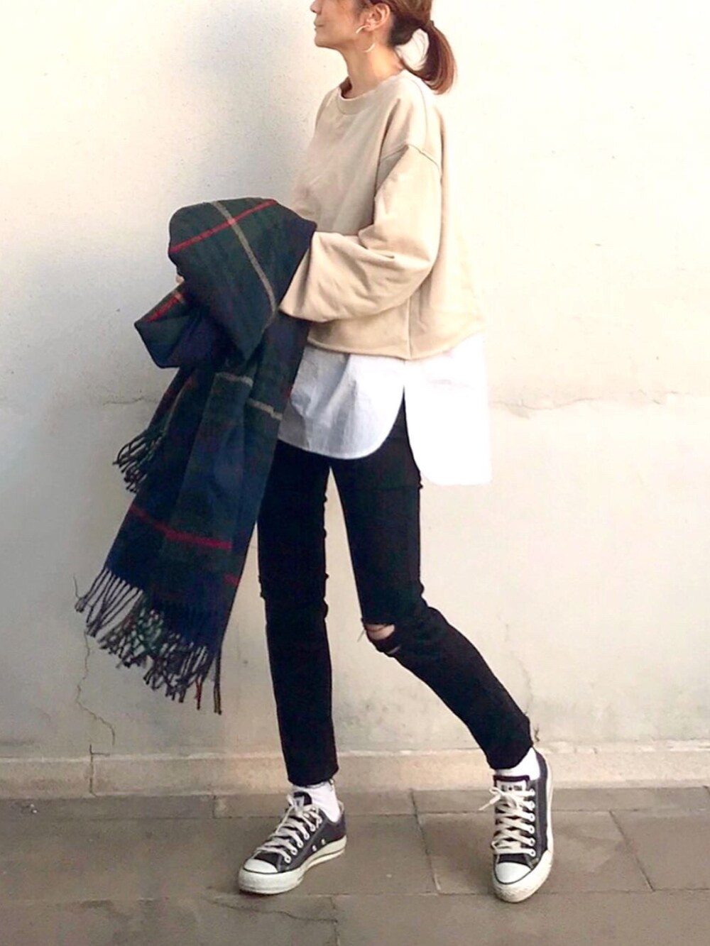 ホワイト系のトートバッグ、ホワイト系のスウェット、ブラック系のスニーカーを着用したレディースの冬コーディネートの2枚目の写真