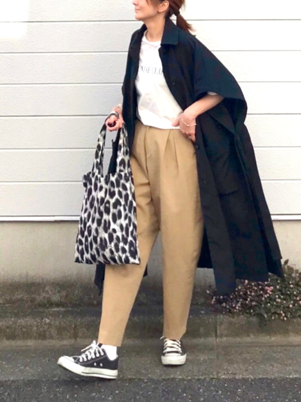 ブラック系のステンカラーコート、ベージュ系のその他パンツ、ブラック系のスニーカーを着用したレディースの春コーディネートの2枚目の写真