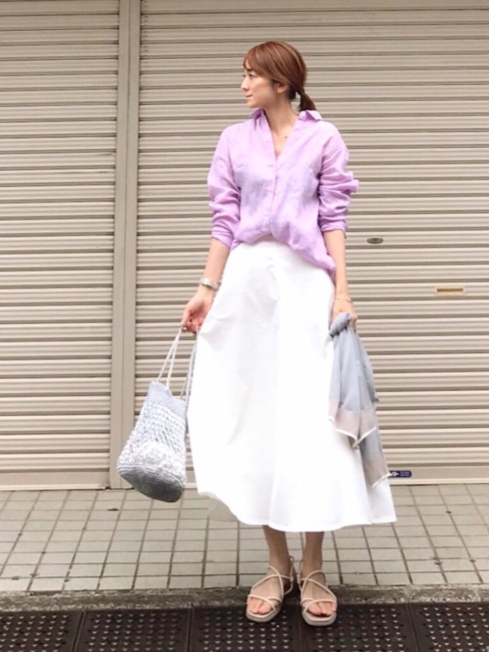 パープル系のシャツ/ブラウス、ホワイト系のスカート、ホワイト系のサンダルを着用したレディースの春コーディネートの2枚目の写真