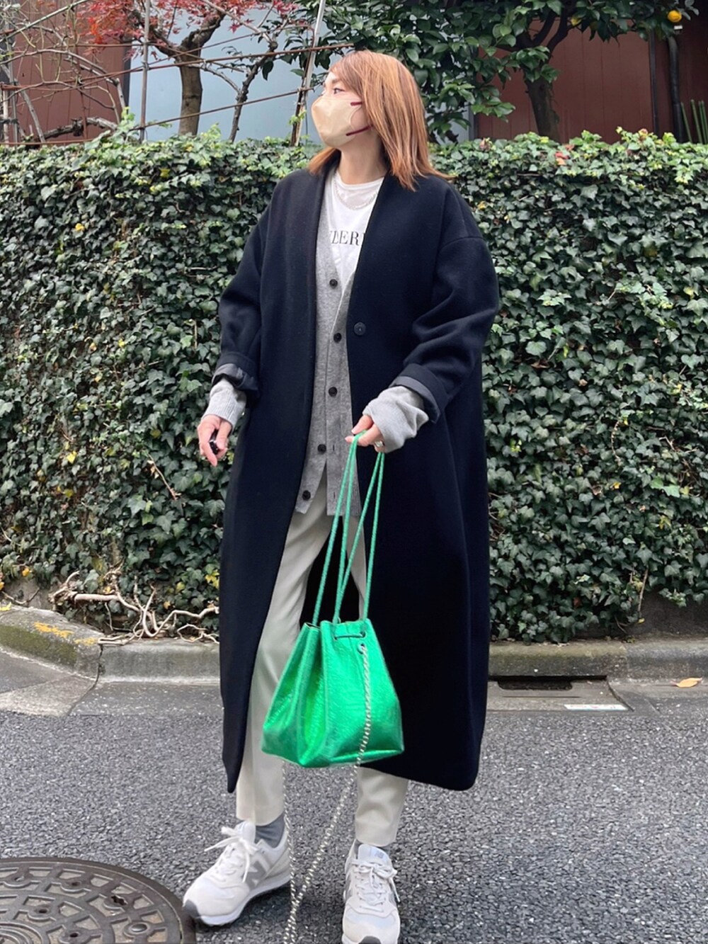 ブラック系のノーカラーコート、グレー系のニット/セーター、ホワイト系のその他パンツを着用したレディースの冬コーディネートの2枚目の写真