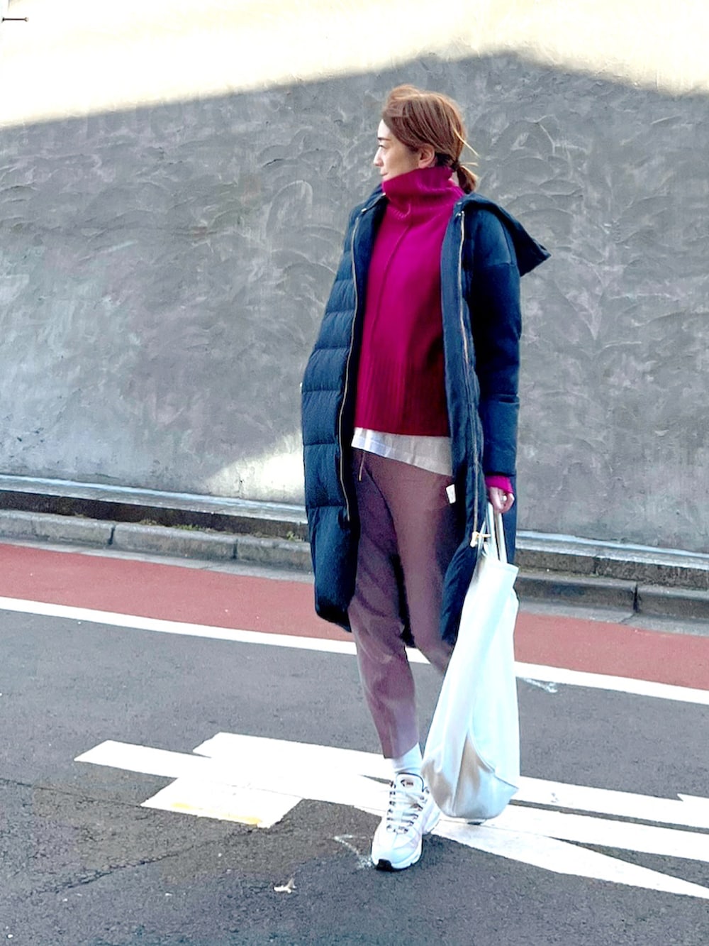 パープル系のニット/セーター、ブルー系のダウンジャケット/コート、パープル系のその他パンツを着用したレディースの冬コーディネートの3枚目の写真