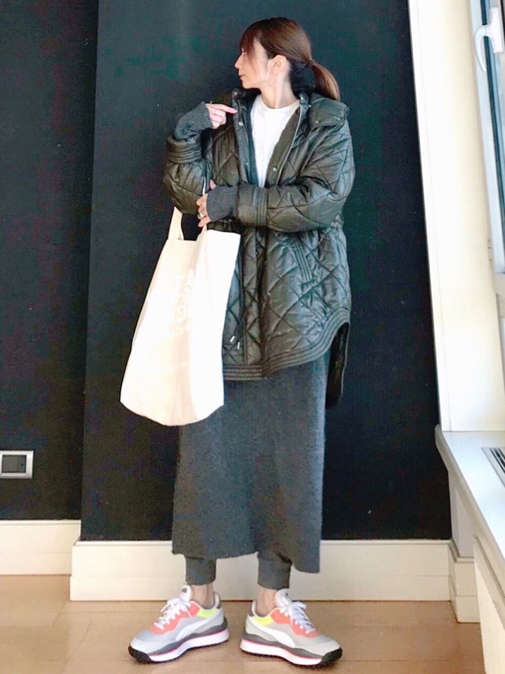 グリーン系のブルゾン、グレー系のワンピース、グレー系のスニーカーを着用したレディースの冬コーディネートの2枚目の写真