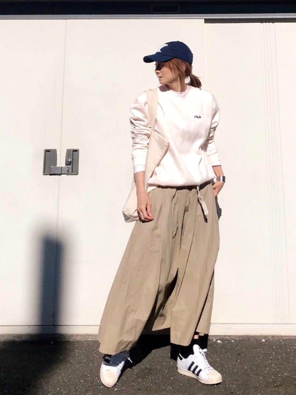 ホワイト系のスウェット、ベージュ系のスカート、ホワイト系のスニーカーを着用したレディースの冬コーディネートの3枚目の写真