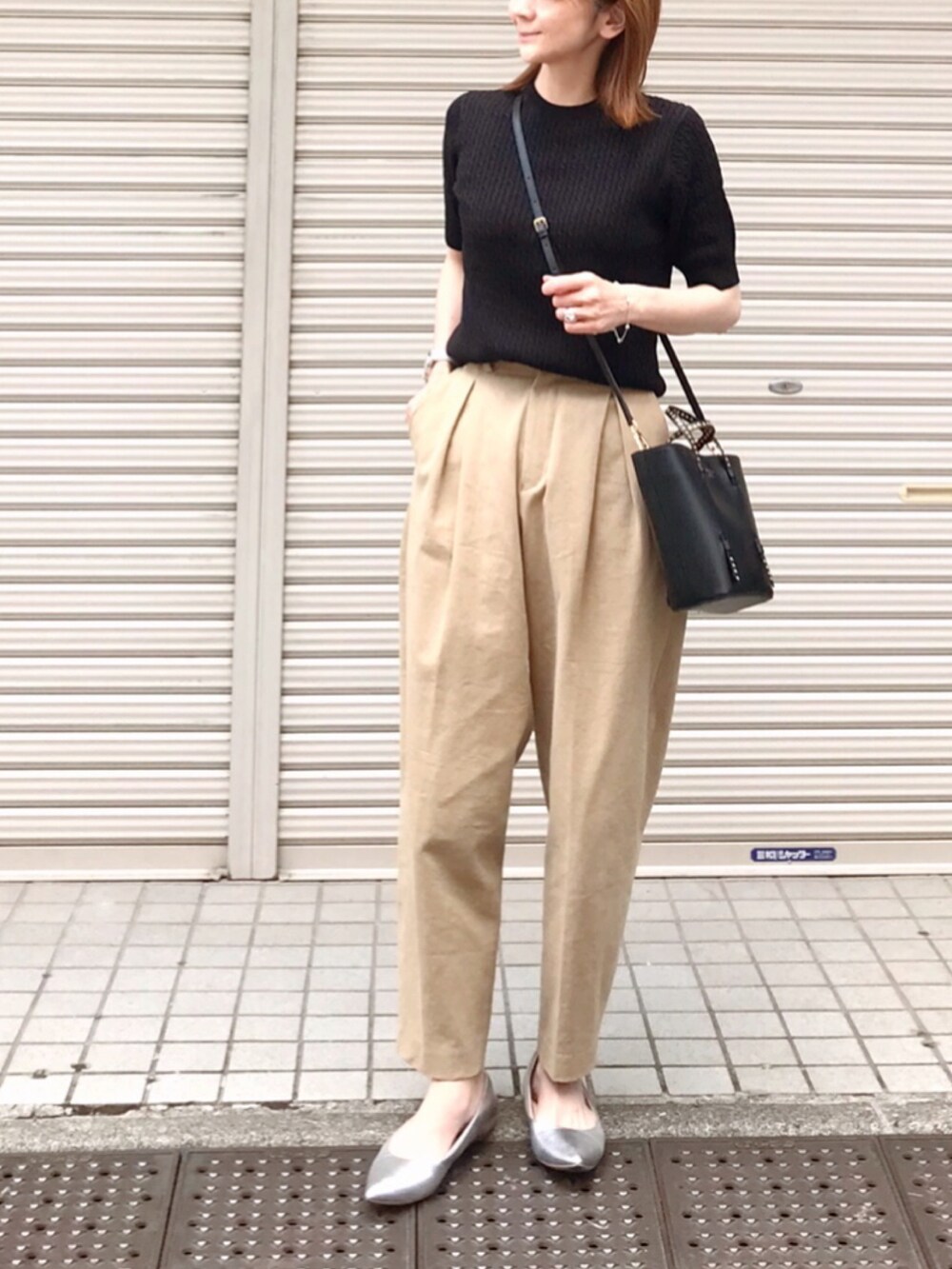 ブラック系のニット/セーター、ベージュ系のその他パンツ、シルバー系のシューズを着用したレディースの春コーディネートの2枚目の写真