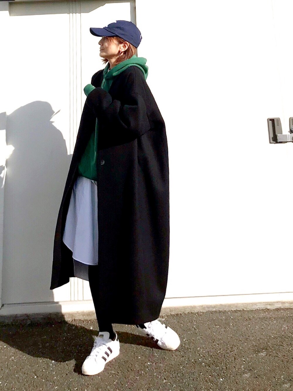 ホワイト系のスニーカー、グリーン系のパーカー、ホワイト系のワンピースを着用したレディースの冬コーディネートの2枚目の写真