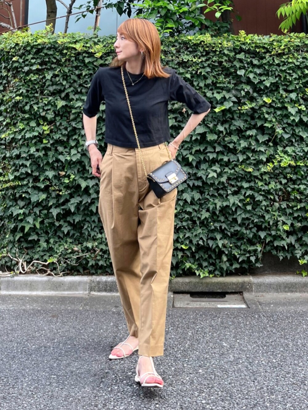 ブラック系のTシャツ/カットソー、ブラック系のバッグ、イエロー系のチノパンツを着用したレディースの夏コーディネートの2枚目の写真