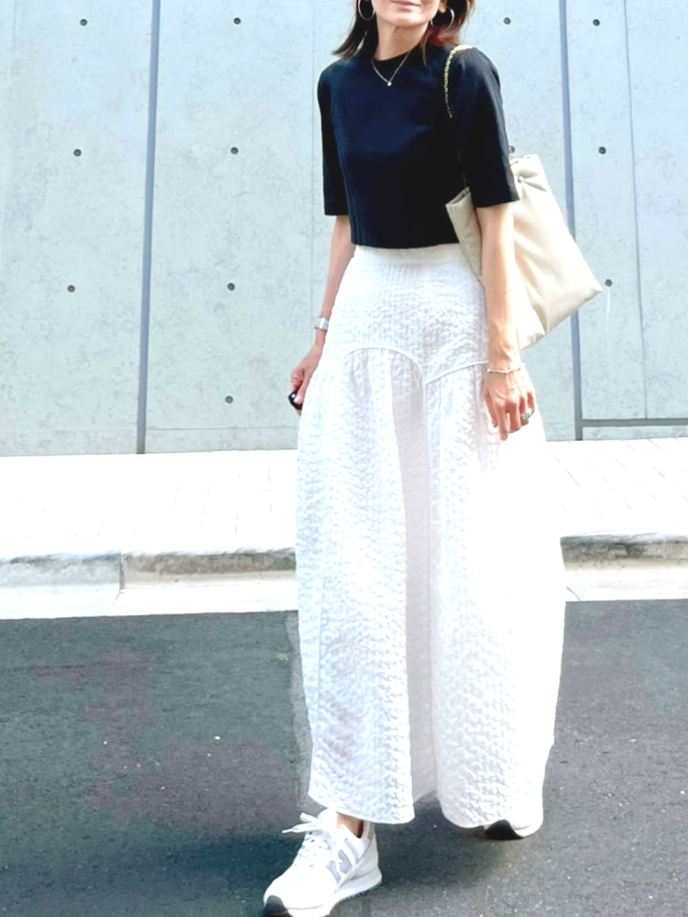 ホワイト系のトートバッグ、ホワイト系のスカート、ホワイト系のスニーカーを着用したレディースの秋コーディネートの2枚目の写真