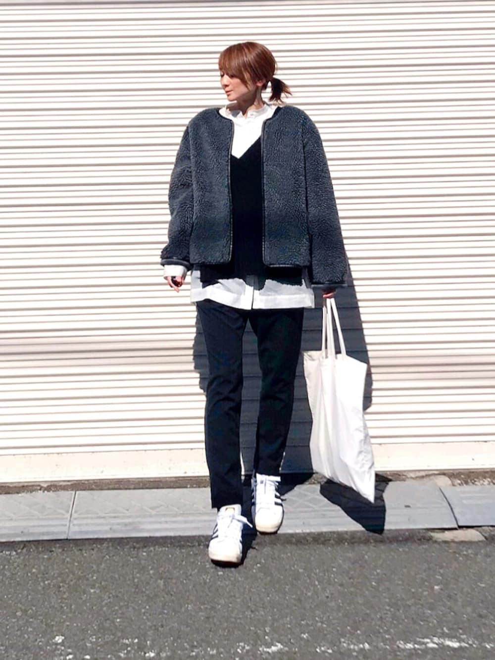 ホワイト系のシャツ/ブラウス、グレー系のブルゾン、ブラック系のニット/セーターを着用したレディースの冬コーディネートの2枚目の写真