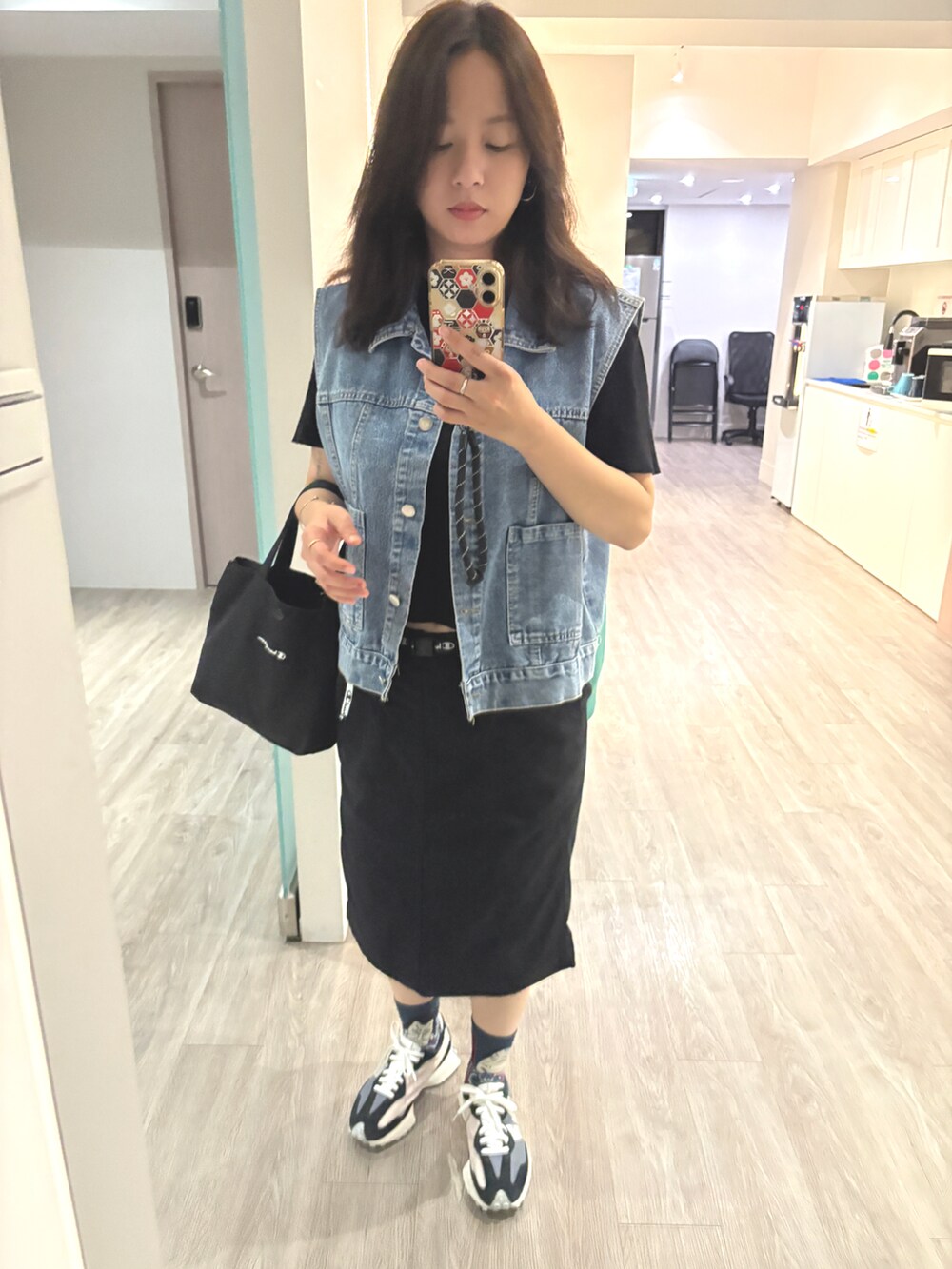 ブラック系のスカートを着用したレディースの秋コーディネートの4枚目の写真