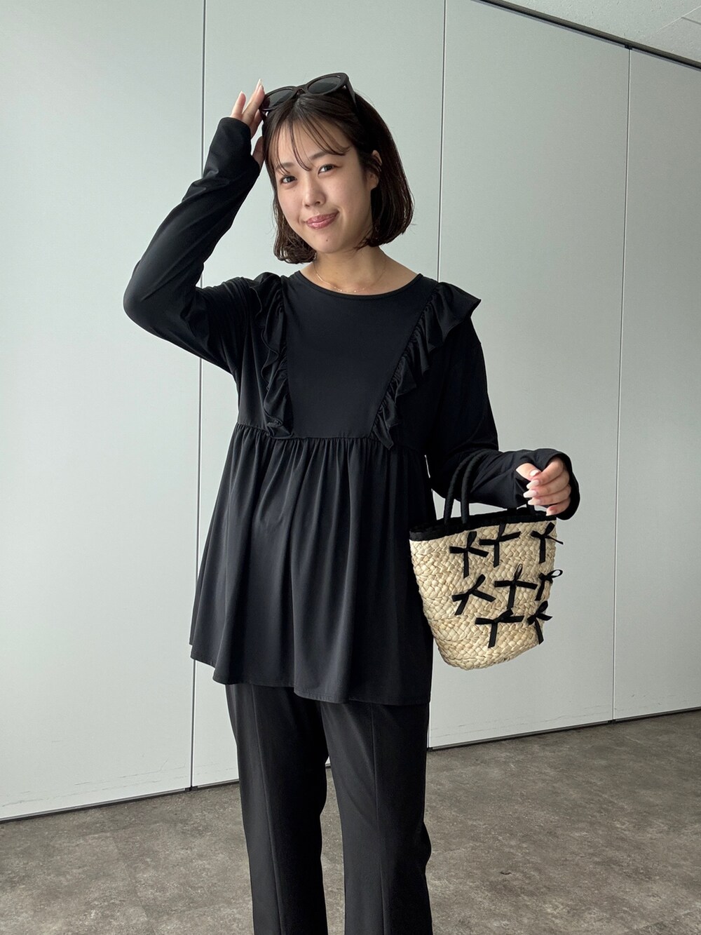 ブラック系のサンダル、ブラック系のかごバッグ、ブラック系のラッシュガードを着用したレディースの夏コーディネートの2枚目の写真