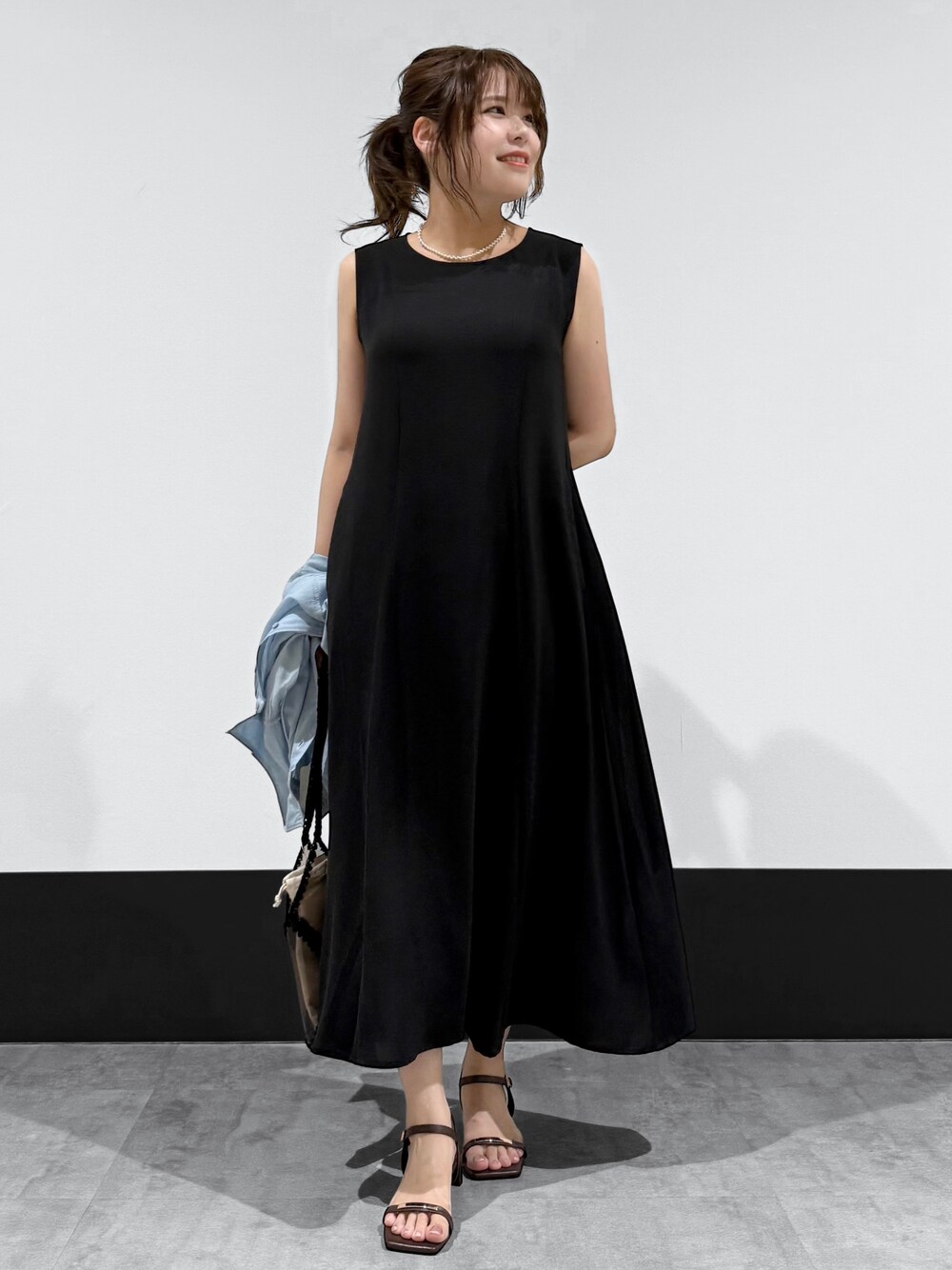 ブルー系のシャツ/ブラウス、ブラック系のワンピース、ブラック系のトートバッグを着用したレディースの夏コーディネートの3枚目の写真