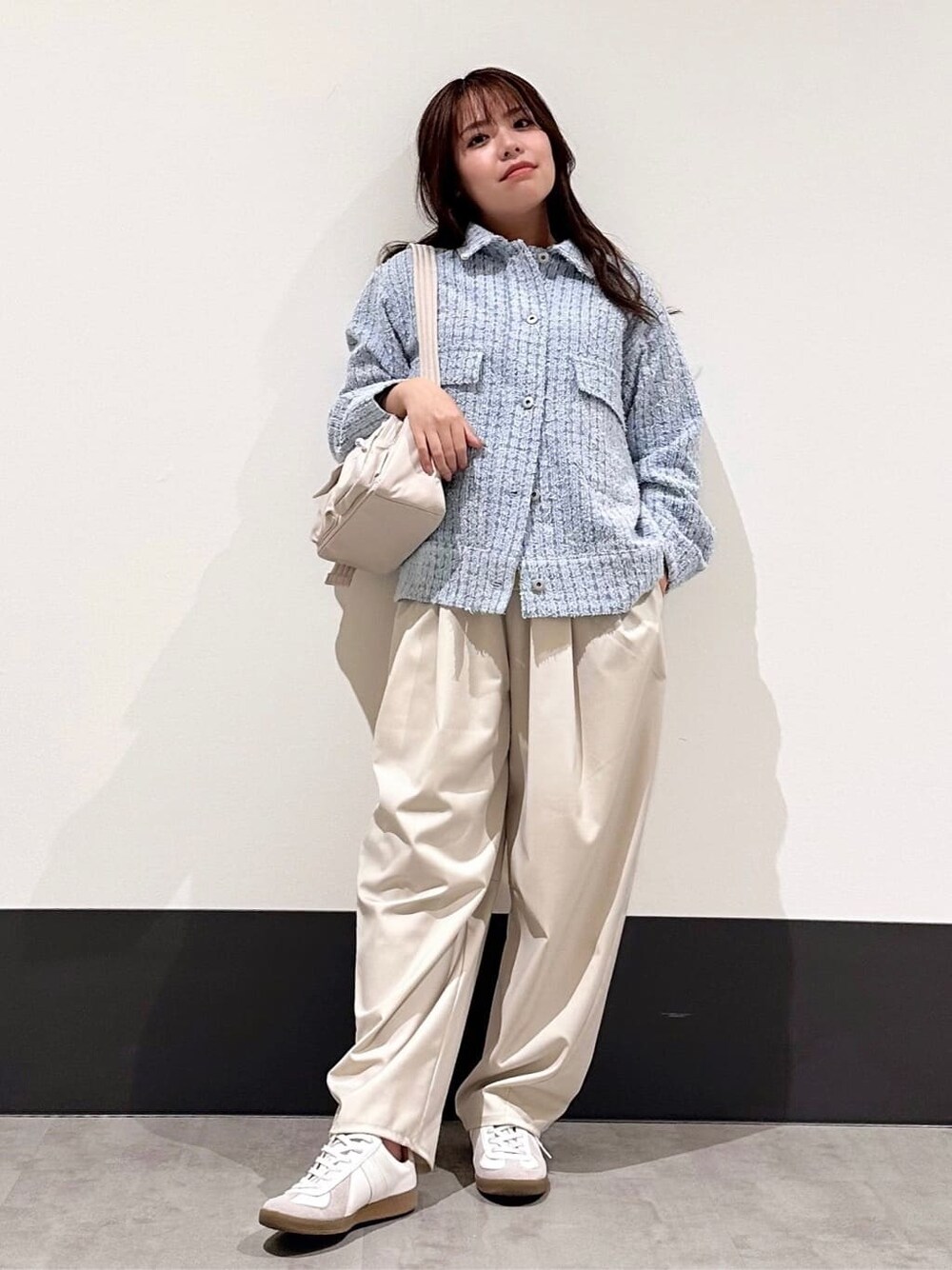 ブルー系のデニムジャケット、イエロー系のニット/セーター、ベージュ系のその他パンツを着用したレディースの春コーディネートの2枚目の写真