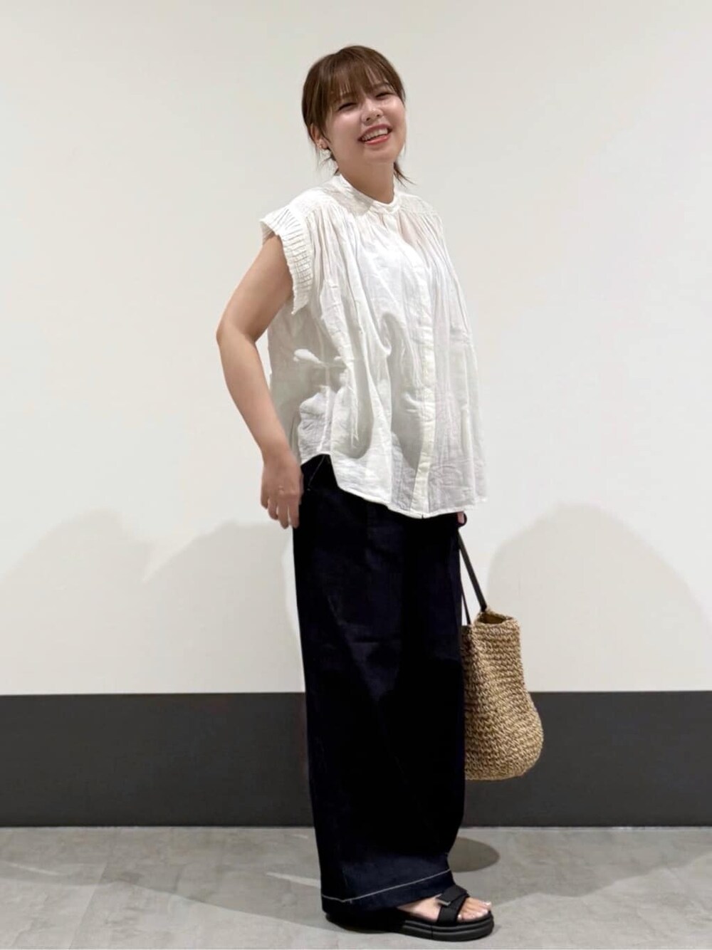 ホワイト系のシャツ/ブラウス、ブルー系のデニムパンツ、ブラック系のトートバッグを着用したレディースの夏コーディネートの2枚目の写真