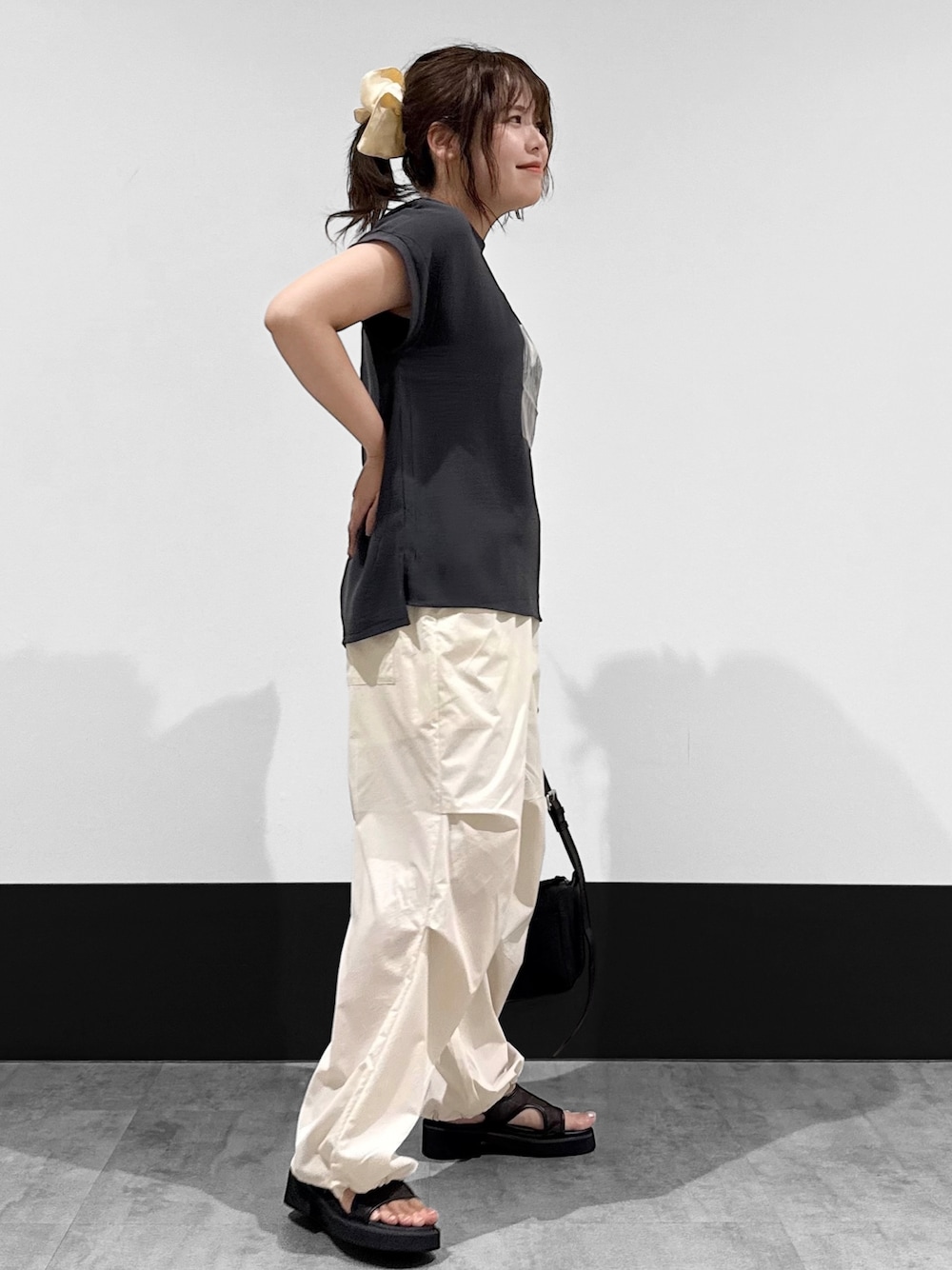 ブラック系のTシャツ/カットソー、ホワイト系のその他パンツ、ブラック系のショルダーバッグを着用したレディースの夏コーディネートの3枚目の写真