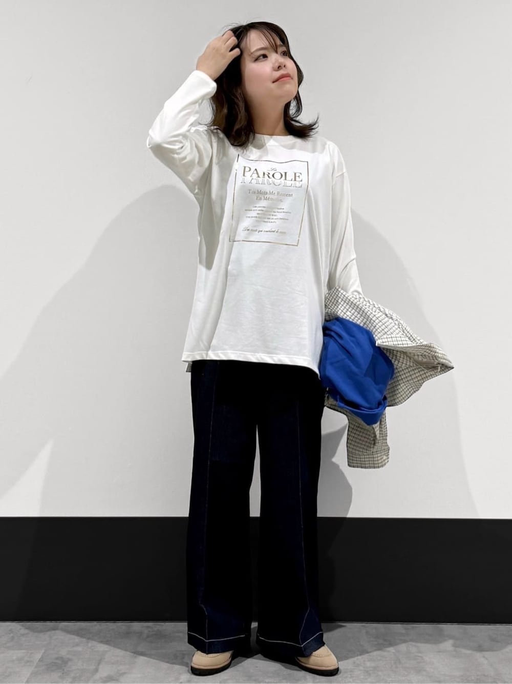 ベージュ系のブルゾン、ホワイト系のTシャツ/カットソー、ブルー系のデニムパンツを着用したレディースの春コーディネートの3枚目の写真