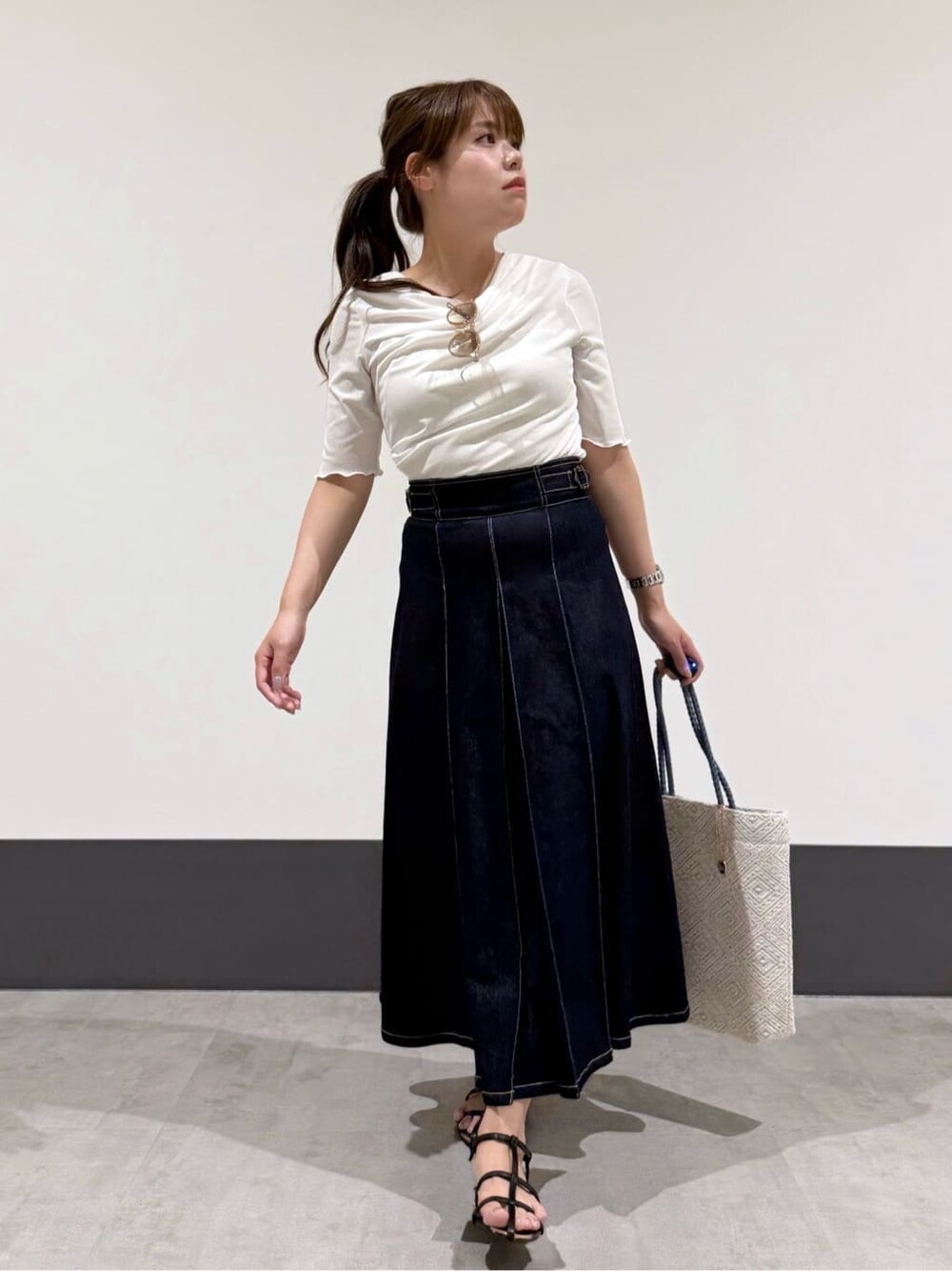 ホワイト系のシャツ/ブラウス、ブルー系のデニムスカート、ブルー系のトートバッグを着用したレディースの夏コーディネートの2枚目の写真