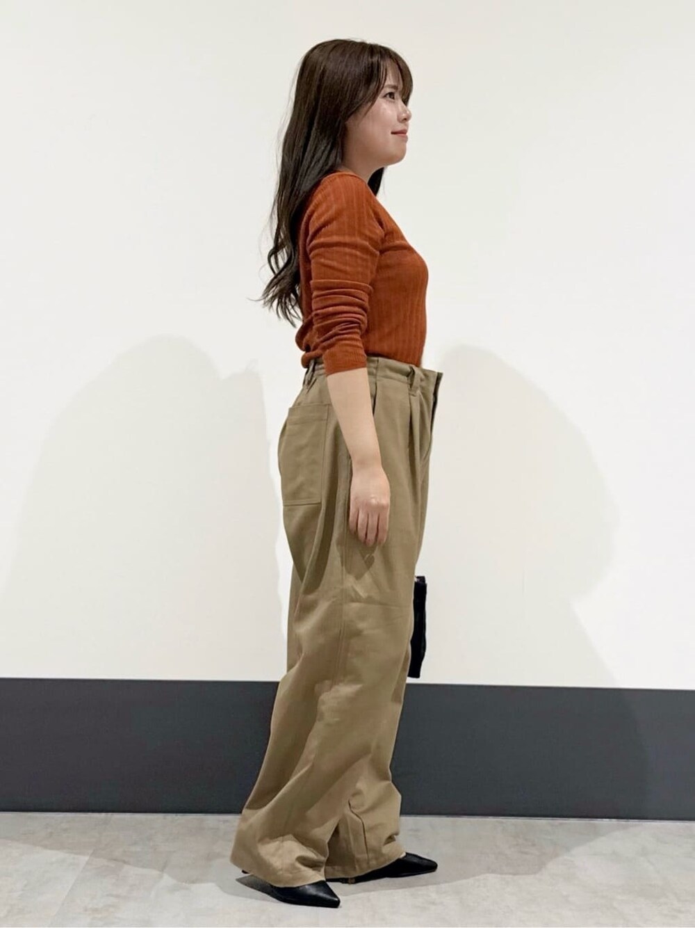 イエロー系のカーディガン/ボレロ、ベージュ系のその他パンツ、ブラック系のトートバッグを着用したレディースの秋コーディネートの2枚目の写真