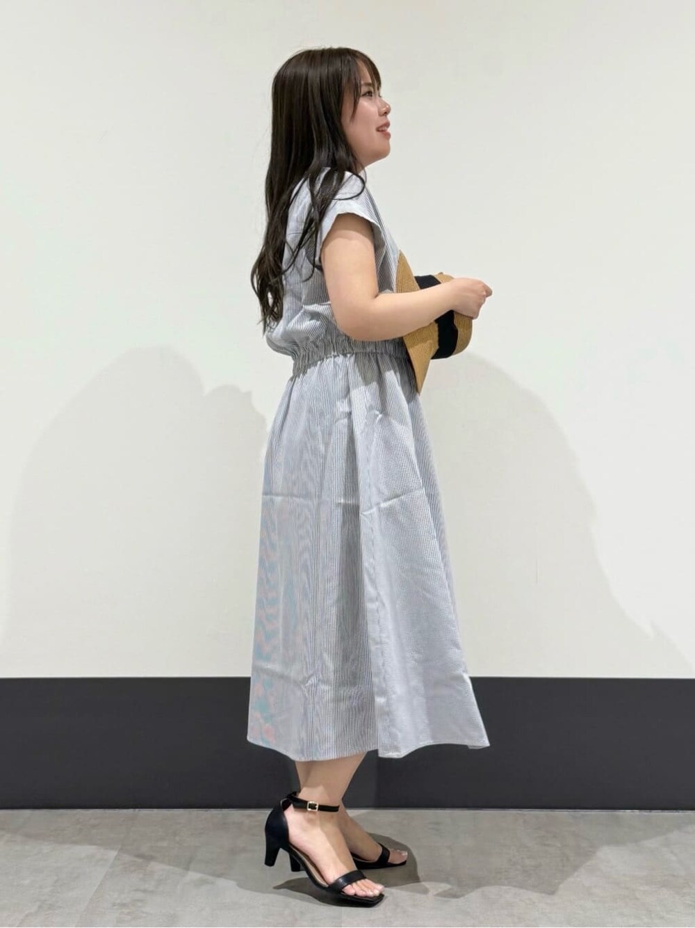 グレー系のワンピース、ベージュ系のハットを着用したレディースの夏コーディネートの2枚目の写真