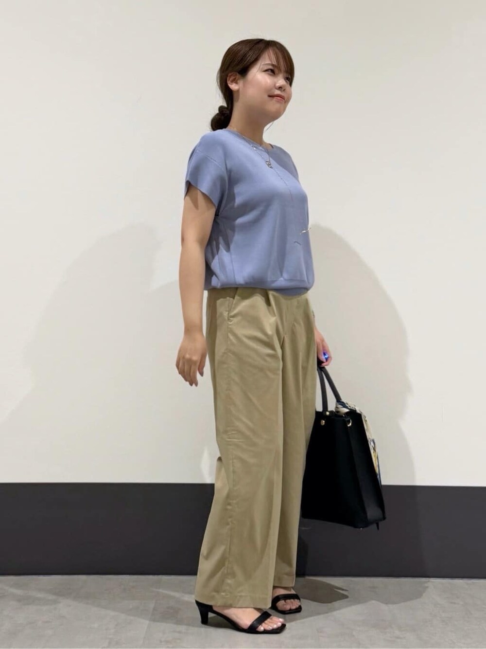 ブルー系のニット/セーター、ベージュ系のその他パンツ、ブラック系のトートバッグを着用したレディースの夏コーディネートの3枚目の写真