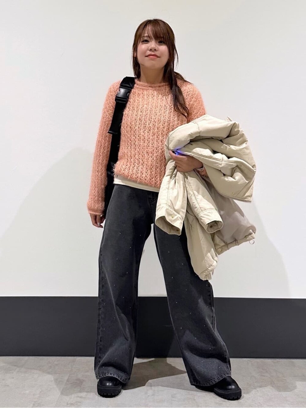 ピンク系のニット/セーター、グレー系のデニムパンツを着用したレディースの冬コーディネートの3枚目の写真