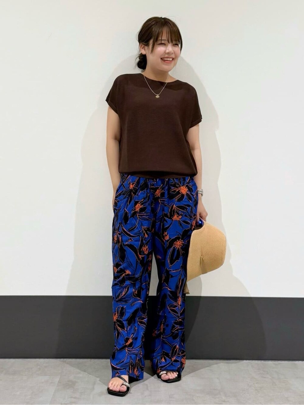 ブラウン系のニット/セーター、ブルー系のその他パンツ、ブラック系のパンプスを着用したレディースの夏コーディネートの2枚目の写真