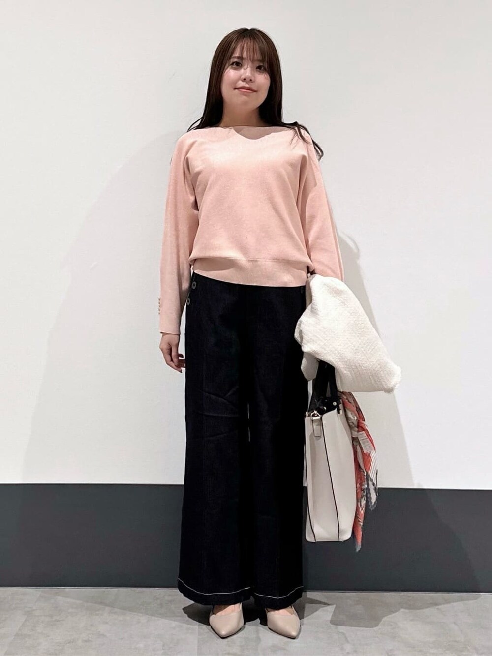 ベージュ系のノーカラージャケット、ピンク系のニット/セーター、ブラック系のデニムパンツを着用したレディースの春コーディネートの3枚目の写真