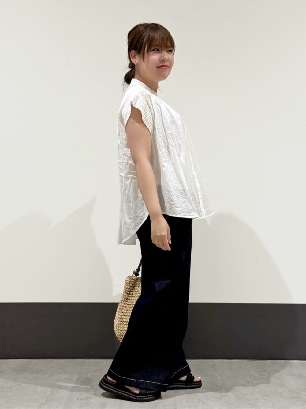 ホワイト系のシャツ/ブラウス、ブルー系のデニムパンツ、ブラック系のトートバッグを着用したレディースの夏コーディネートの3枚目の写真