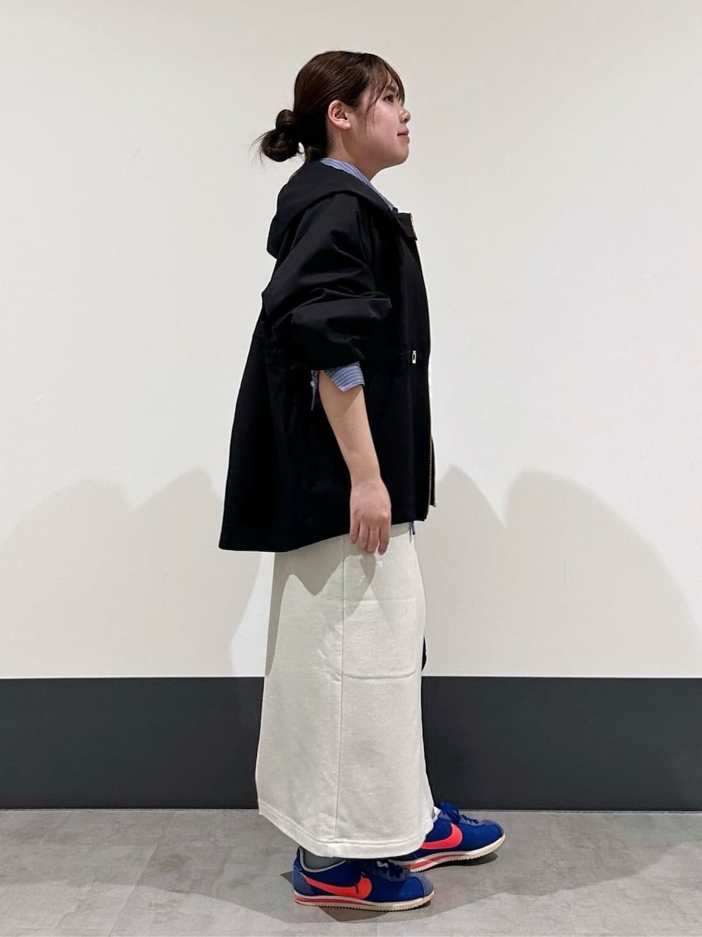 ブラック系のブルゾン、ブルー系のシャツ/ブラウス、ブラック系のショルダーバッグを着用したレディースの春コーディネートの2枚目の写真