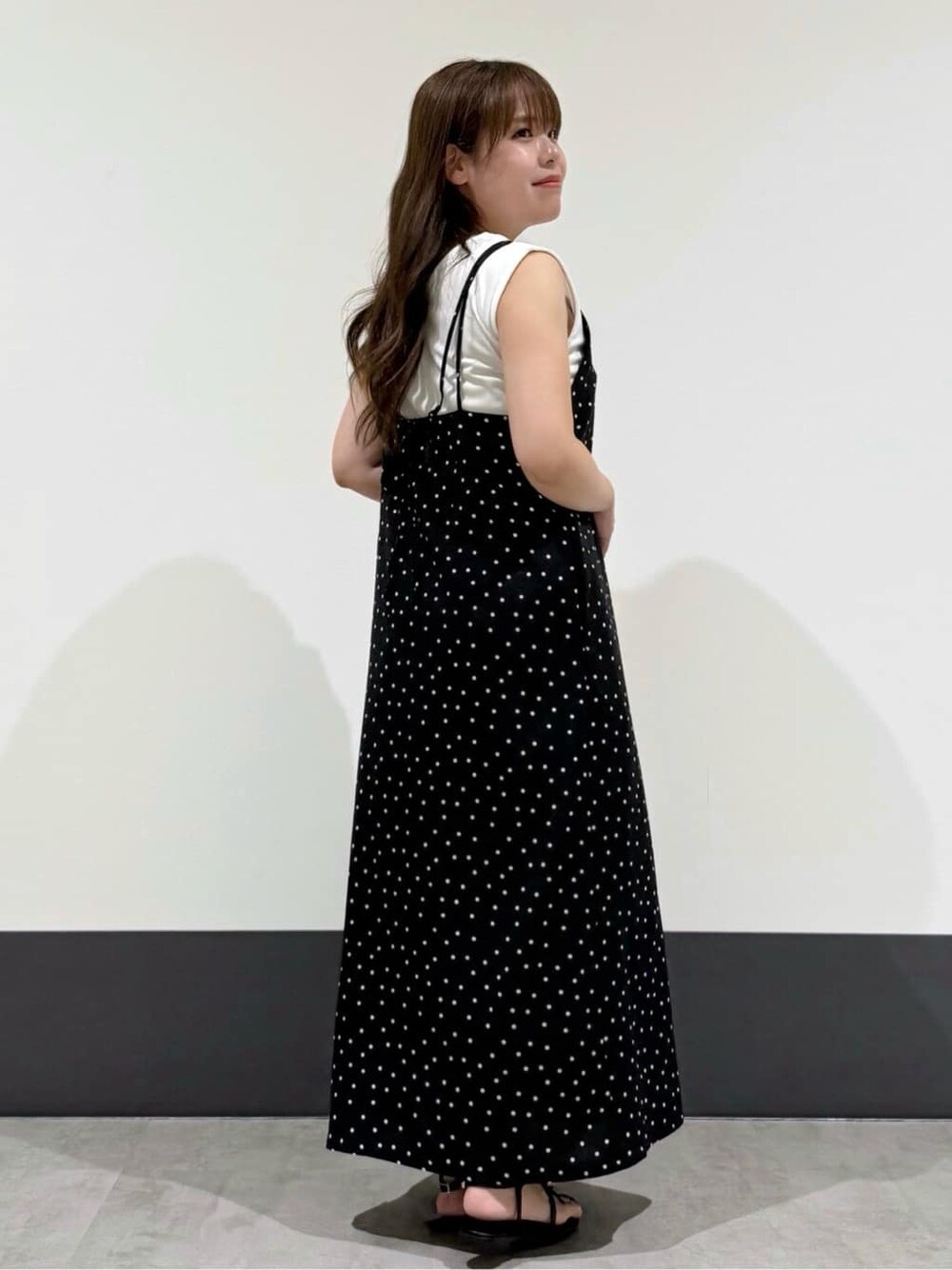 ホワイト系のタンクトップ、ブラック系のワンピース、ベージュ系のトートバッグを着用したレディースの夏コーディネートの3枚目の写真