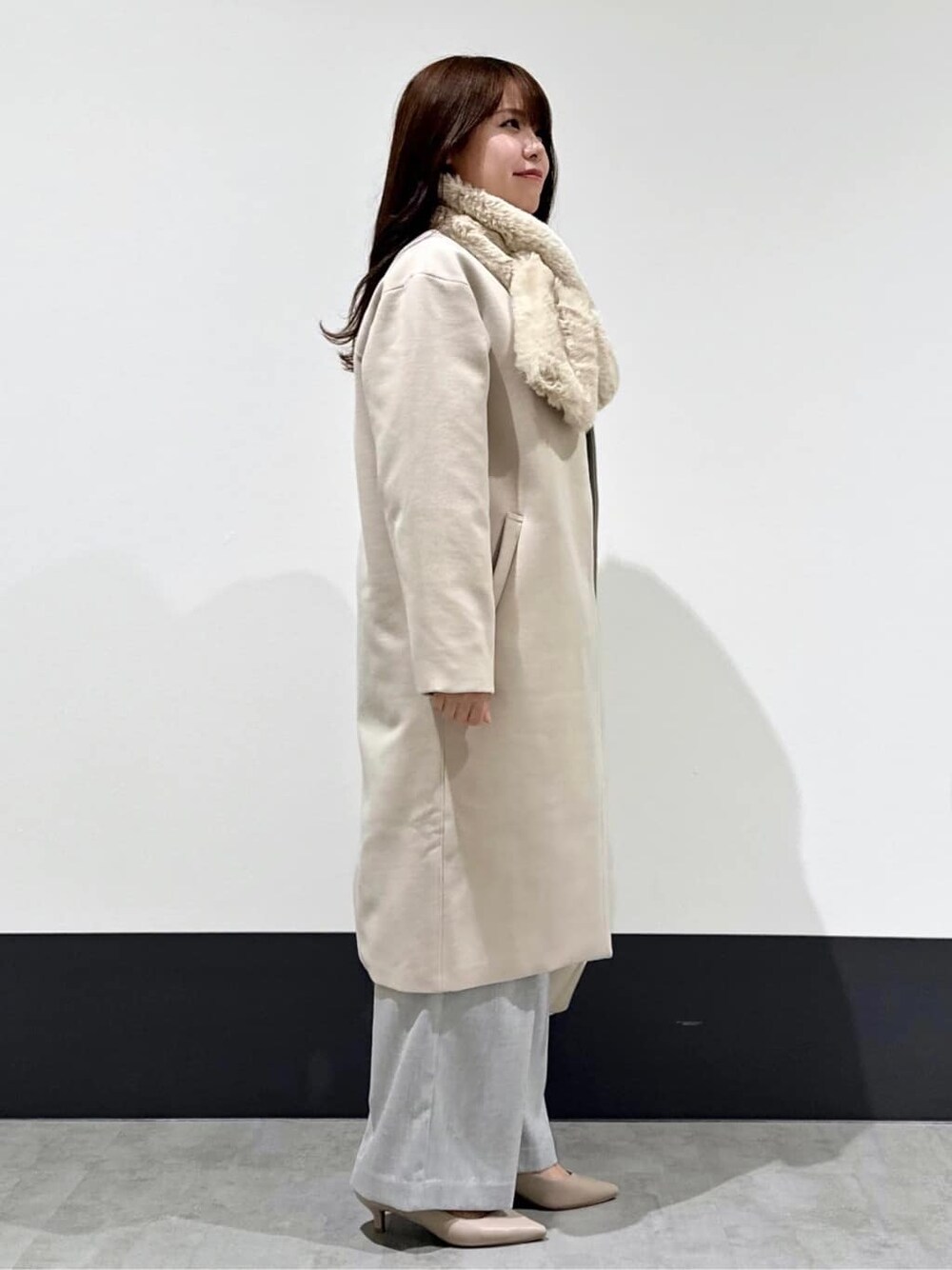 グリーン系のニット/セーター、ホワイト系のショルダーバッグ、ベージュ系のパンプスを着用したレディースの冬コーディネートの2枚目の写真