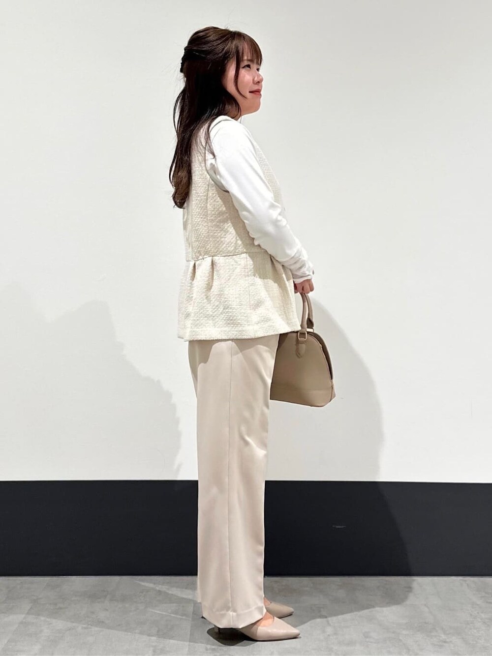 ベージュ系のベスト、ベージュ系のその他パンツ、ベージュ系のショルダーバッグを着用したレディースの春コーディネートの2枚目の写真