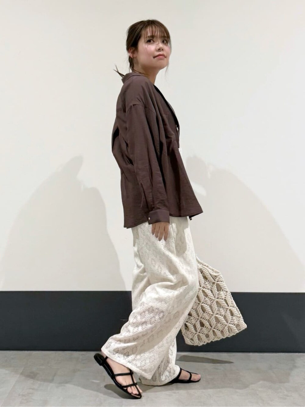 ブラウン系のシャツ/ブラウス、ホワイト系のその他パンツ、ホワイト系のトートバッグを着用したレディースの春コーディネートの3枚目の写真