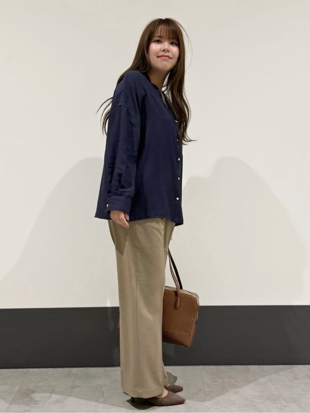 ブルー系のシャツ/ブラウス、ベージュ系のその他パンツ、ブラウン系のボストンバッグを着用したレディースの秋コーディネートの2枚目の写真