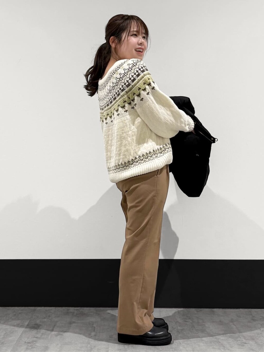ブラック系のその他アウター、ベージュ系のニット/セーター、ベージュ系のその他パンツを着用したレディースの冬コーディネートの4枚目の写真