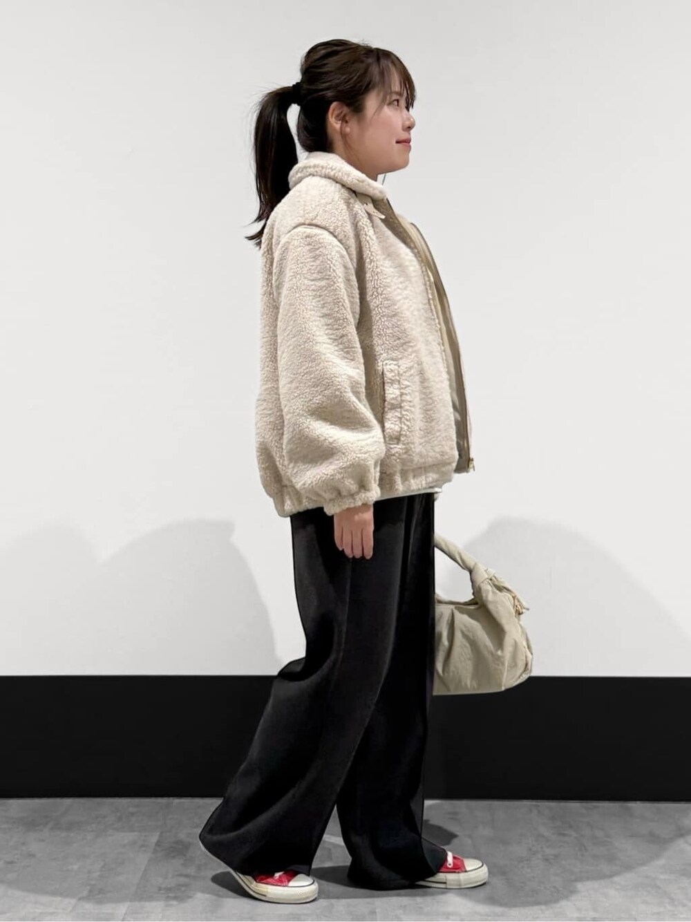 ベージュ系のブルゾン、グレー系のニット/セーター、ブラック系のその他パンツを着用したレディースの秋コーディネートの2枚目の写真