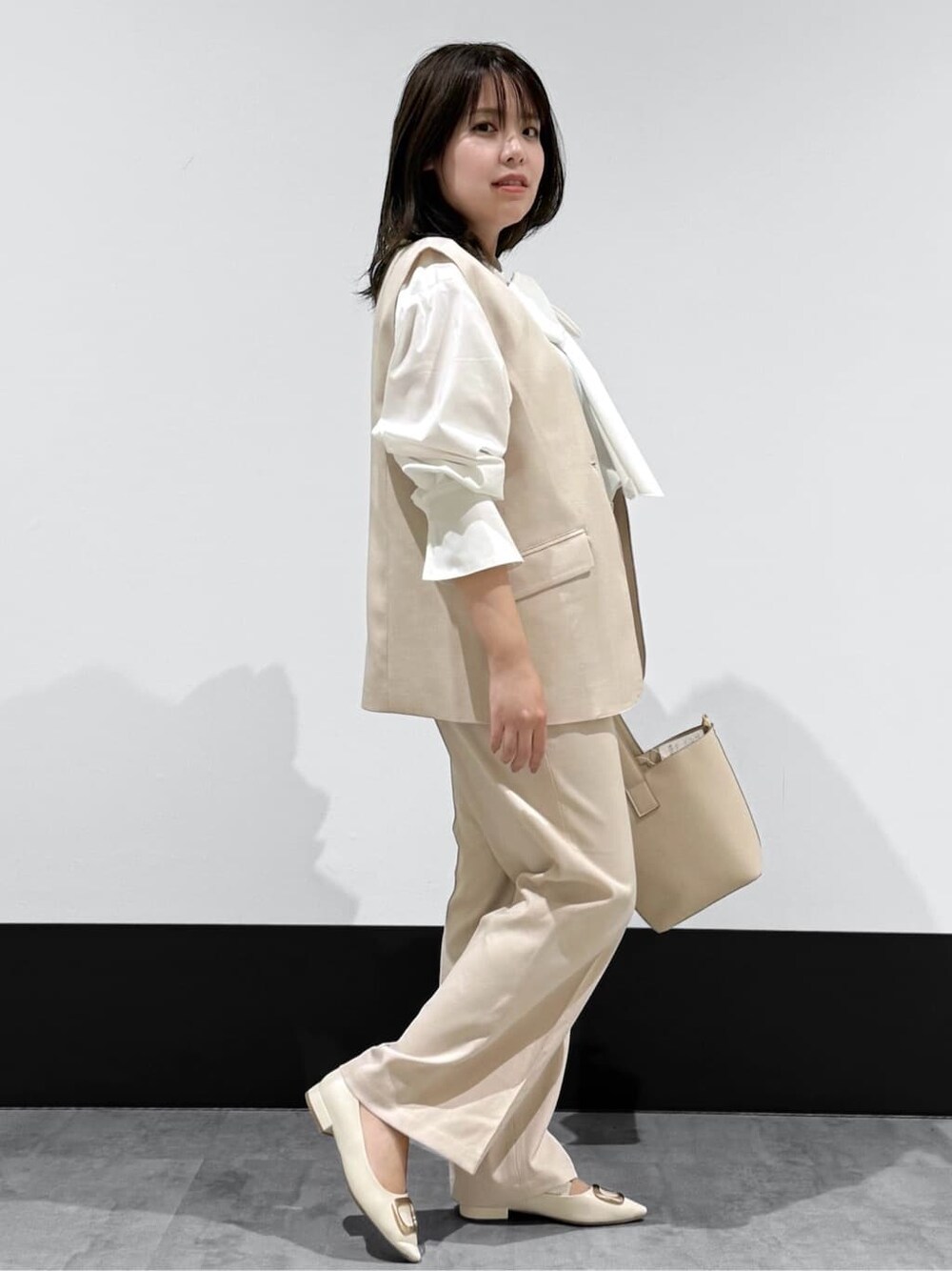 ベージュ系のベスト、ホワイト系のシャツ/ブラウス、ベージュ系のその他パンツを着用したレディースの冬コーディネートの2枚目の写真