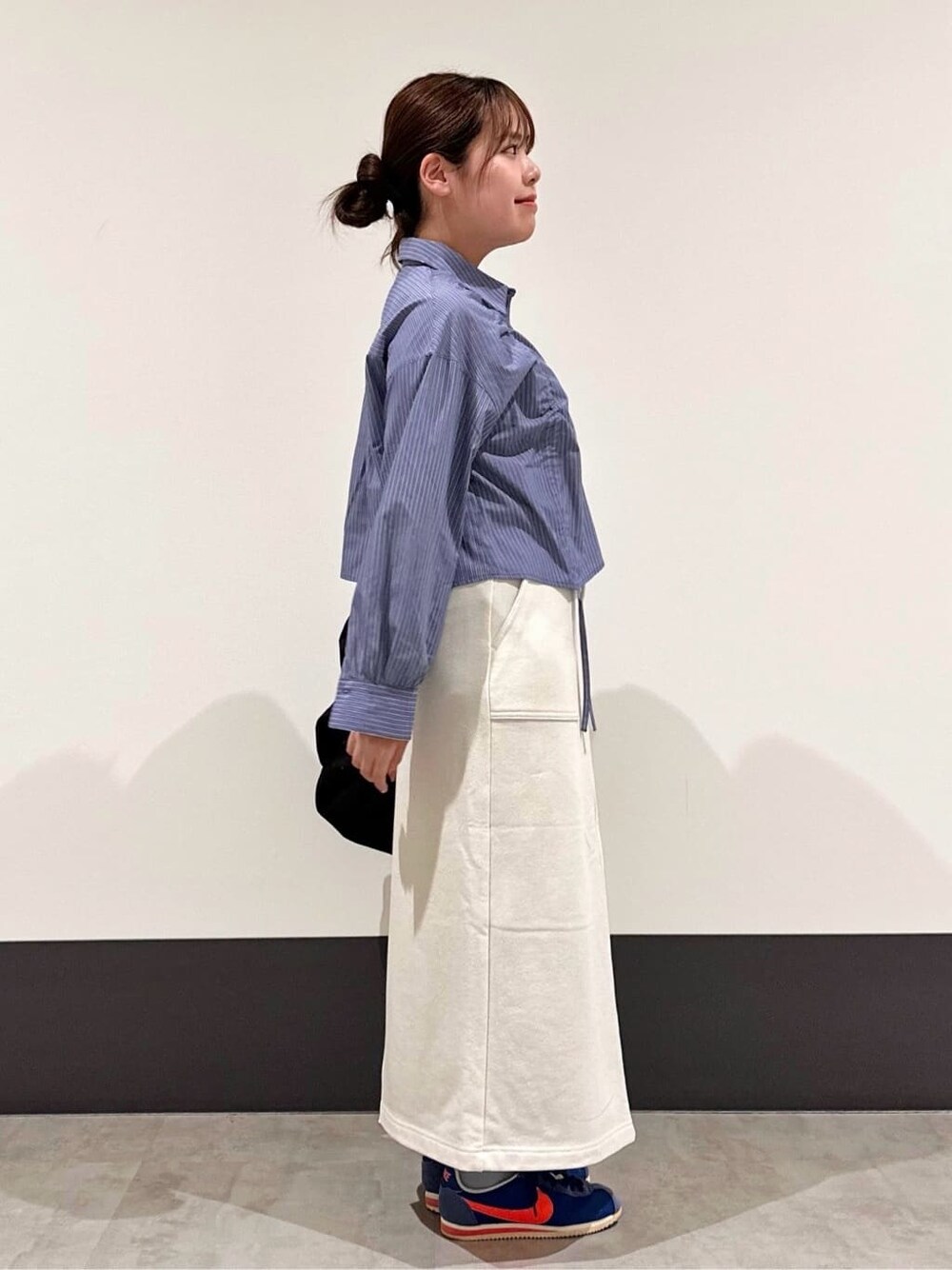 ブラック系のブルゾン、ブルー系のシャツ/ブラウス、ブラック系のショルダーバッグを着用したレディースの春コーディネートの4枚目の写真
