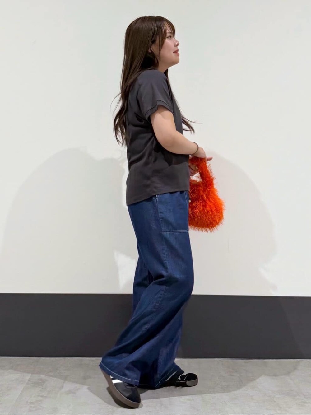 ブラック系のTシャツ/カットソー、ブルー系のその他パンツ、オレンジ系のショルダーバッグを着用したレディースの秋コーディネートの2枚目の写真