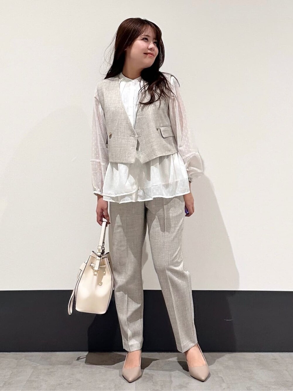 ベージュ系のベスト、ホワイト系のシャツ/ブラウス、ベージュ系のその他パンツを着用したレディースの冬コーディネートの2枚目の写真
