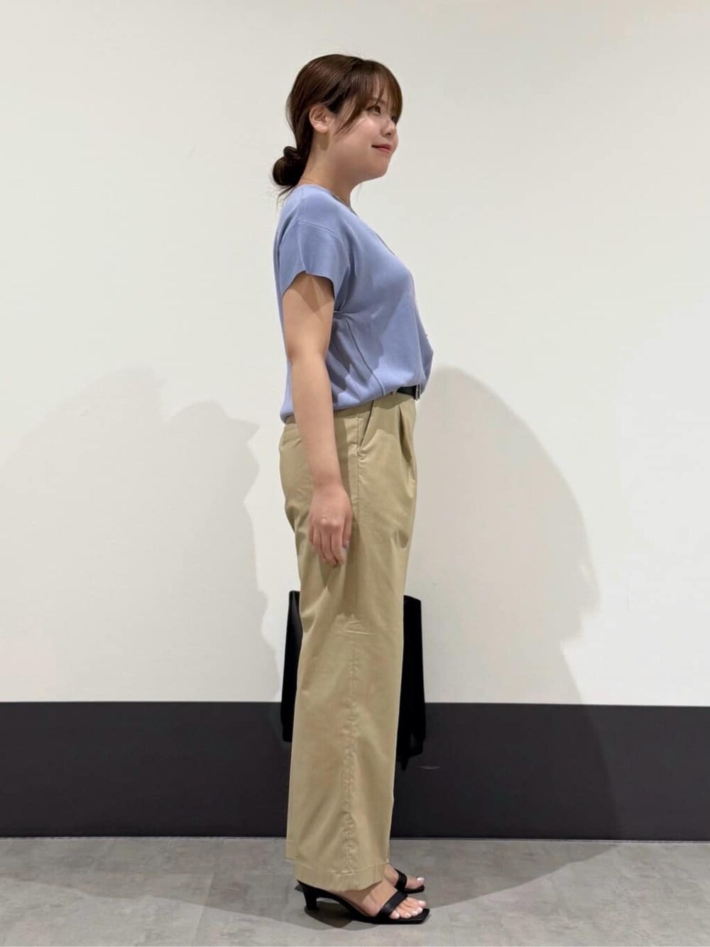 ブルー系のニット/セーター、ベージュ系のその他パンツ、ブラック系のトートバッグを着用したレディースの夏コーディネートの4枚目の写真