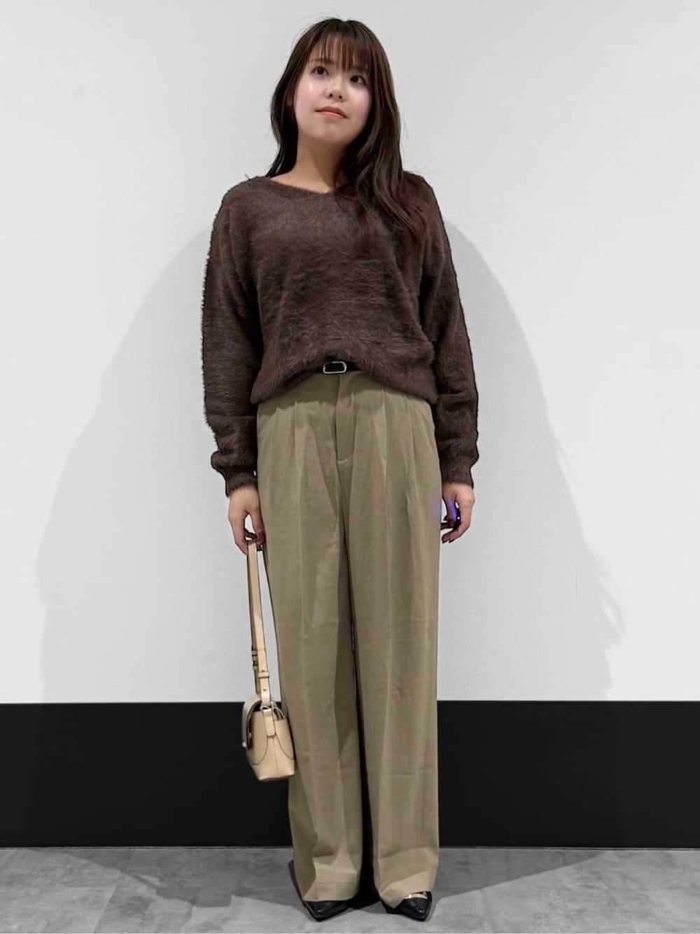ベージュ系のその他パンツ、ベージュ系のショルダーバッグ、ブラック系のパンプスを着用したレディースの冬コーディネートの2枚目の写真